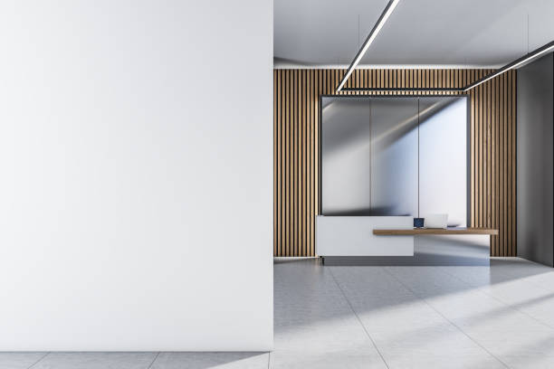 istock Front view on blank white wall for your poster or image frame in sunlit spacious office on modern eco style reception desk background. 3D rendering, mockup 1405982337