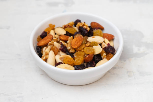 istock dry fruits in white small bowl on gray ceramic 1405983349