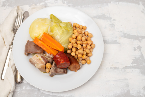 typical portuguese dish boiled meat, sausages and vegetables on white dish