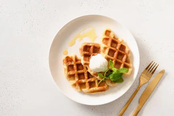 Photo of Trendy delicious breakfast with croffles on a white background. Croissant as waffle.