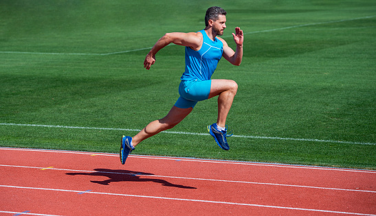 Front view of a runner pulling a sled with weights on a track