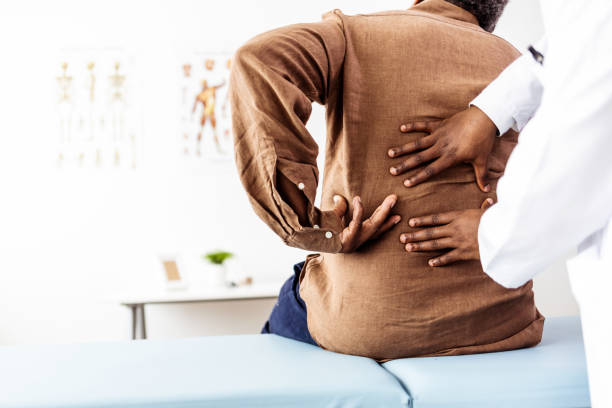Doctor physiotherapist doing healing treatment on man's back stock photo