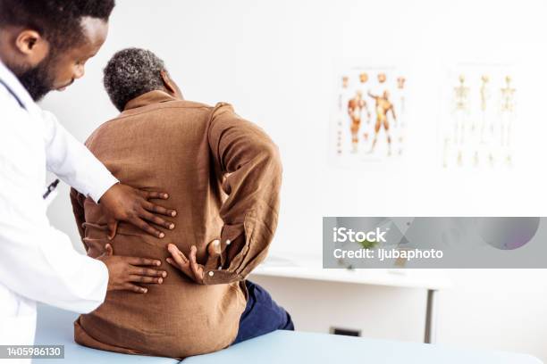Male Doctor Hands Doing Physical Therapy By Extending The Back Of A Male Patient Stock Photo - Download Image Now