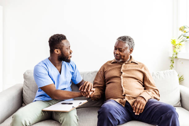 medico che parla con un paziente maschio anziano in una visita domiciliare - patient doctor male talking foto e immagini stock
