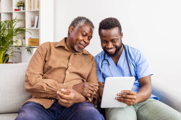 istock Caregiver or healthcare worker with senior man patient, using tablet and explaining 1405986245