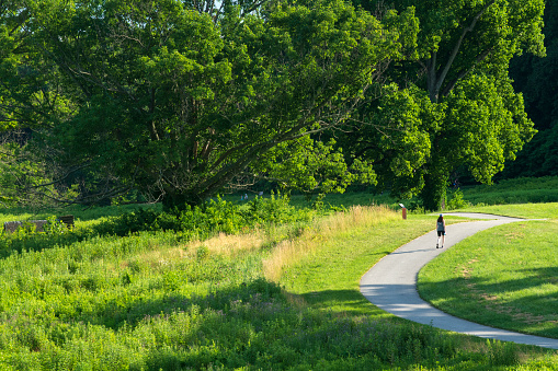 King of Prussia, USA - June 28, 2022. A woman walking on paved trail at Valley Forge National Historic Park, Pennsylvania, USA