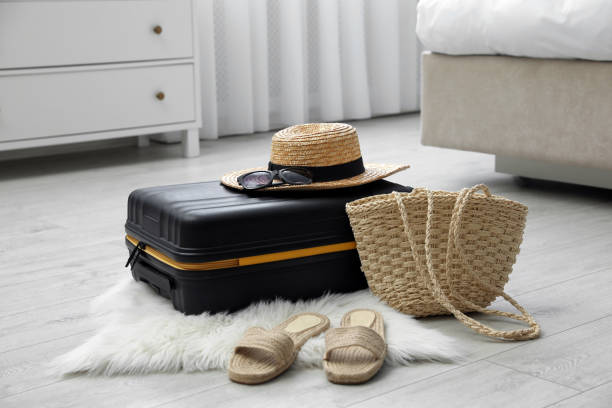 istock Suitcase packed for trip and summer accessories on floor indoors 1405986906