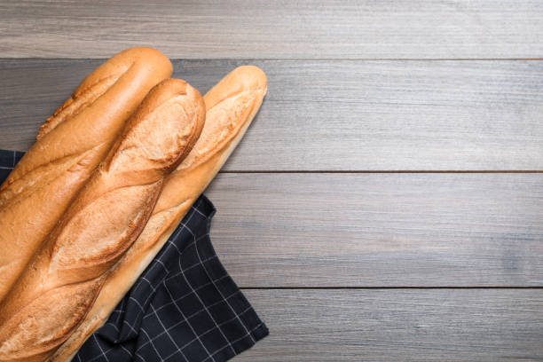 istock Tasty baguettes on wooden table, flat lay. Space for text 1405987731