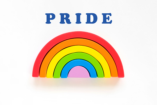 Wooden rainbow isolated on a white background. The rainbow toy puzzle. LGBT flag gay pride community, equal rights movement and gender equality life concept. Flat lay, top view, copy space. Banner with place for text. Studio shot. Happy pride month.