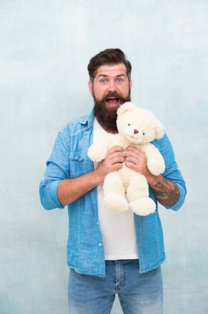 happy valentines day present. gift for your beloved. bearded male casual style. man with beard on surprised face. happy birthday party. toy shop concept. brutal hipster hold lovely bear toy happy valentines day present. gift for your beloved. bearded male casual style. man with beard on surprised face. happy birthday party. toy shop concept. brutal hipster hold lovely bear toy. man with teddy bear stock pictures, royalty-free photos & images