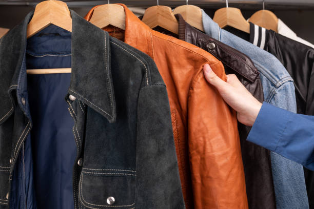 Person choosing vintage jacket in a used goods store stock photo