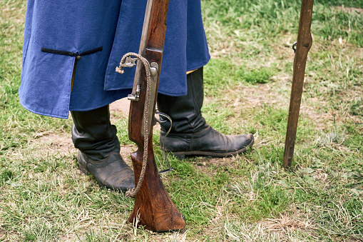 A man in a vintage Swedish military uniform with a gun in his hands. Reconstruction of the events of the Russian-Swedish War