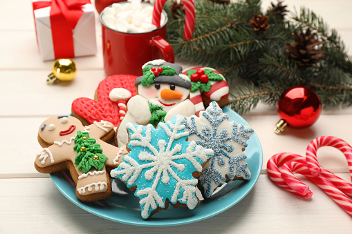 Delicious homemade Christmas cookies and festive decor on white wooden table