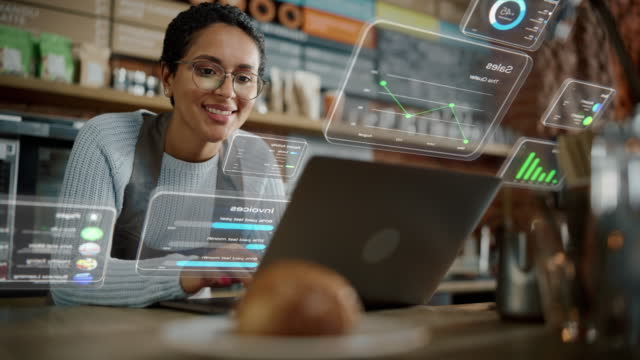 Beautiful Latina Coffee Shop Owner is Working on Laptop Computer and Checking Inventory in a Cozy Cafe. Restaurant Manager Browsing Internet and Chatting with Friends. VFX Augmented Reality Concept.