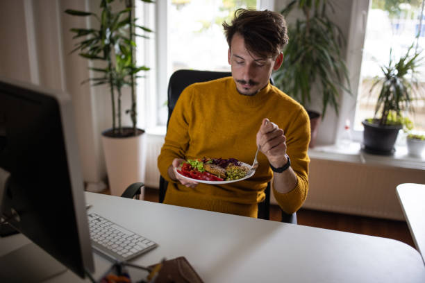 istock Caucasian man working at the office while eating healthy meal 1405992964
