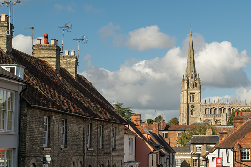 Facade of old terraced cottage brick houses with Cathedral tower visible in Saffron Walden, England