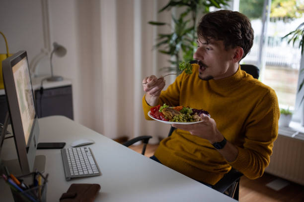 istock Caucasian man working at the office while eating healthy meal 1405993259