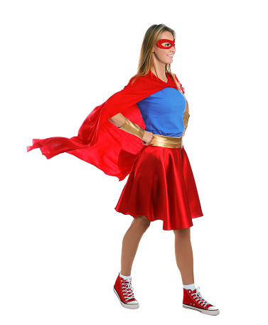 Confident woman wearing superhero costume on white background
