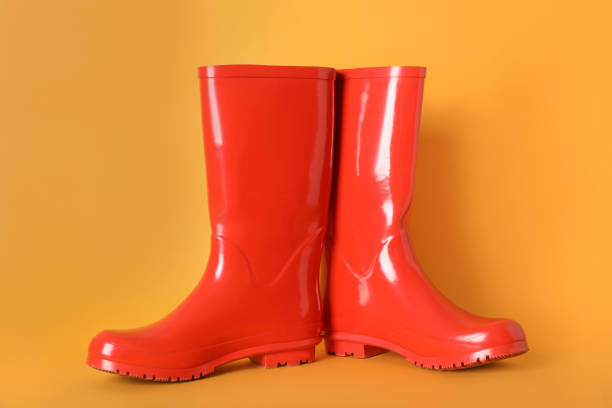 istock Pair of red rubber boots on orange background 1405993597