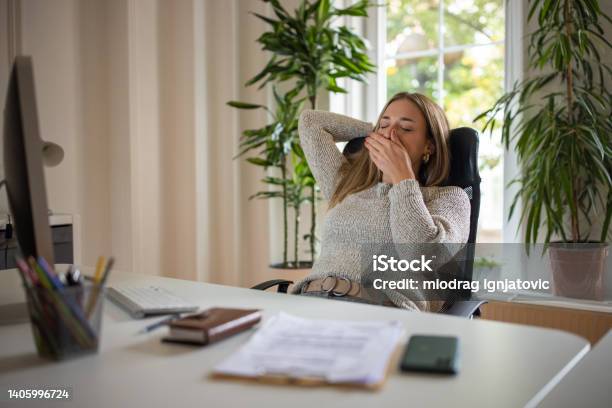Tired Young Caucasian Woman In The Office Stock Photo - Download Image Now - Yawning, Tired, Exhaustion