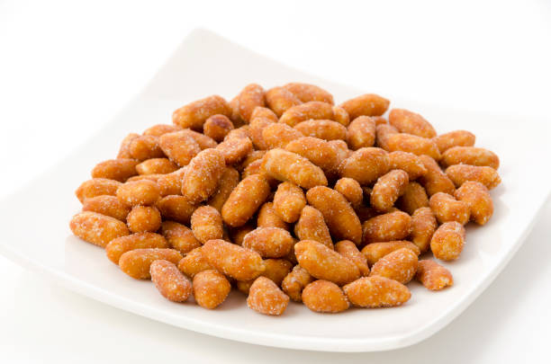 istock Honey roasted peanuts in a white plate on a white background 1405997774