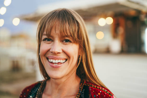 istock Young girl smiling on camera with beach bar on background - Focus on face 1405998312