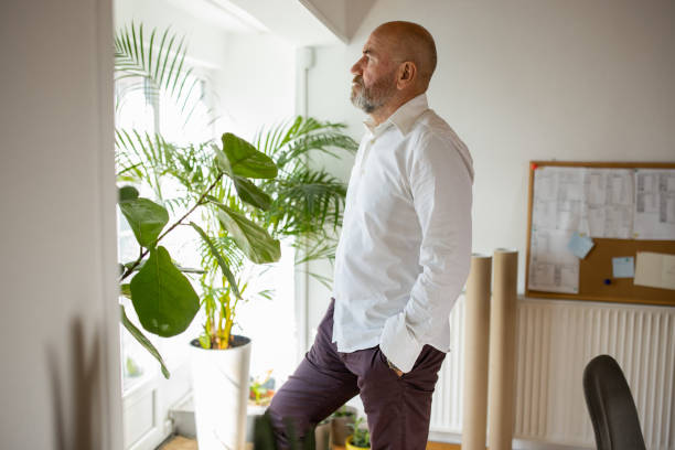 istock Pensive Caucasian man looking through window 1405999154