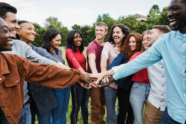 istock Young diverse team having fun stacking hands outdoor - Focus on hands 1406000388