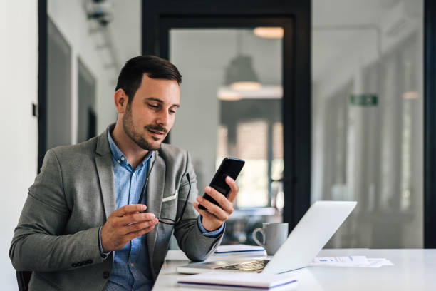 istock Confident male entrepreneur networking on cellphone while working at office desk 1406002842