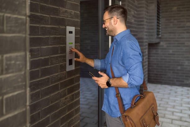 istock Smiling professional using intercom while standing at building entrance in the city 1406002989