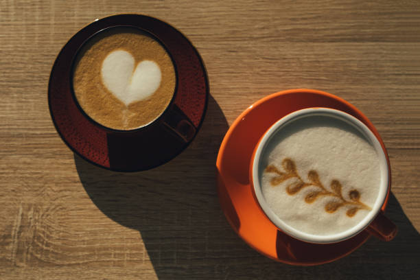 istock Two cups with cappuccino coffee on wooden table. Top view. 1406005818
