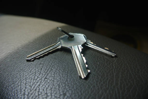 istock Metal keys in silver colour on gray leather surface 1406006226