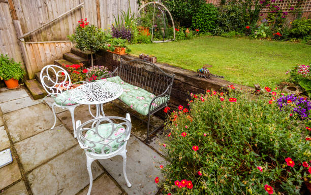 istock Garden patio with table and chairs and flowers in bloom 1406009491
