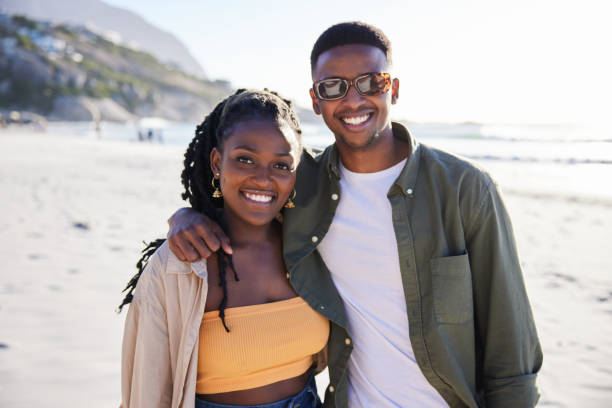 istock Smiling young couple standing on a sandy beach in summer 1406011477