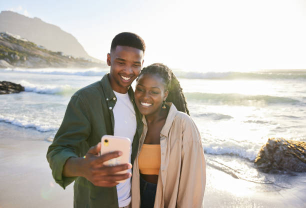 istock Smiling young couple taking a selfie together on a beach in summer 1406012556