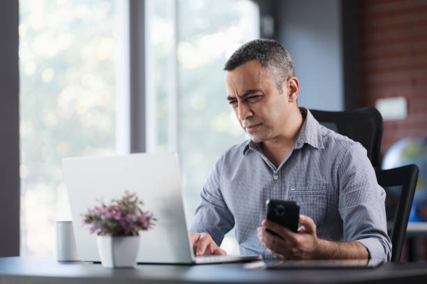 istock Tired Businessman In The Office Has Difficulty To See Texts On His Smartphone, Concept For The Beginning Of Presbyopia Just After The Age Of 40 Years. 1406019837