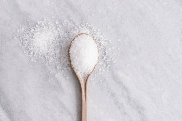 istock White crystal sugar on a ceramic spoon on a grey marble background 1406020502