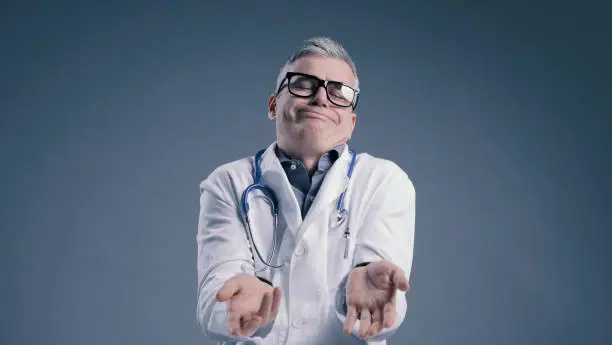 Photo of Funny clueless doctor shrugging and looking at camera