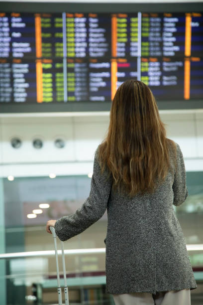 istock A young woman is looking at the departure board 1406020957