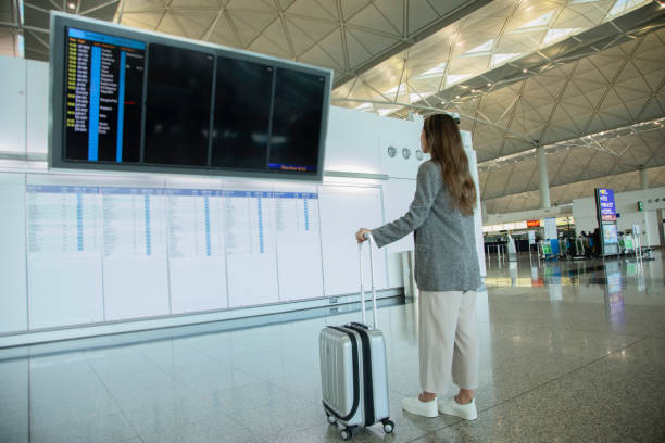 istock A young woman is looking at the departure board 1406021048