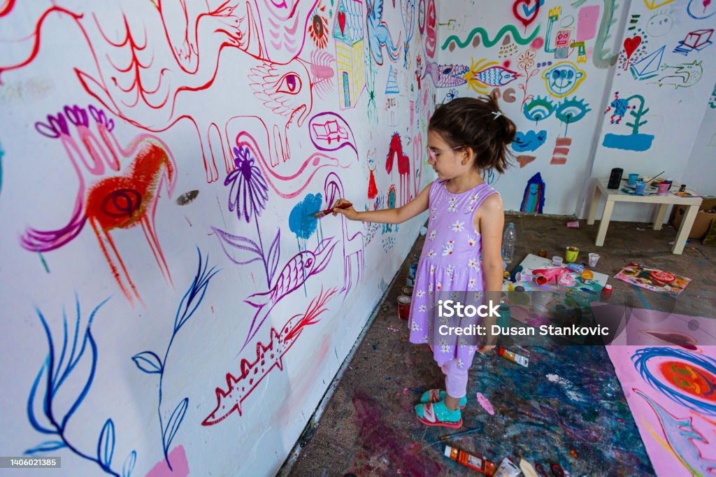 Children's mural on the wall Curious girl using his free time to create art Child Stock Photo
