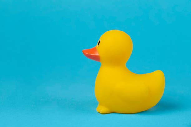 istock Side view of a yellow rubber duck on a blue background. 1406021952