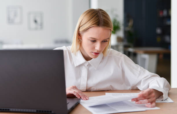 istock Young woman working with laptop and documents. 1406022395