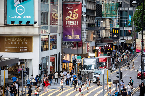Hong Kong - June 29, 2022 : Pedestrians at the Queen's Road Central in Hong Kong. Queen’s Road is Hong Kong’s oldest street, built by the British Royal Engineers from 1841 to 1843.