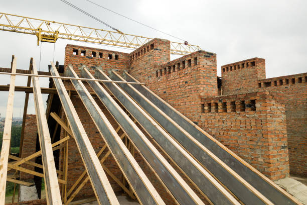 istock Unfinished brick apartment building with wooden roof structure under construction. 1406023890