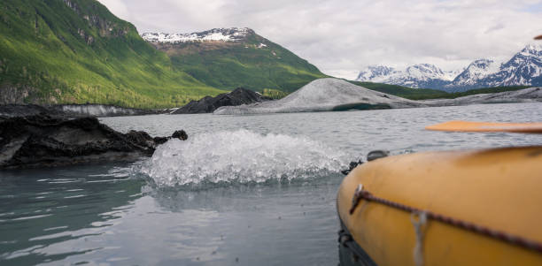 kajakfahren in alaska, gelbes kanuboot mit paddel in der nähe des eisbergs - extreme sports kayaking kayak adventure stock-fotos und bilder