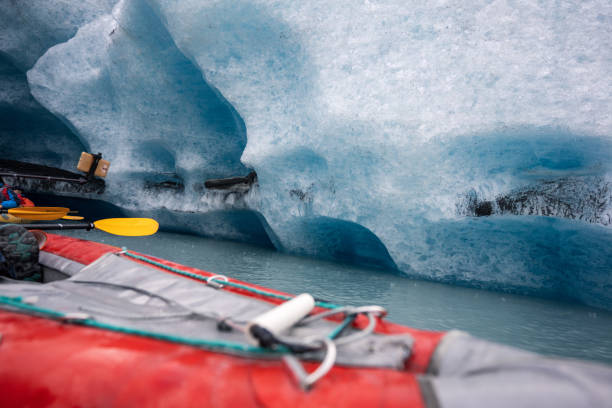 kajakfahren in alaska, gelbes kanuboot mit paddel in der nähe des eisbergs - extreme sports kayaking kayak adventure stock-fotos und bilder