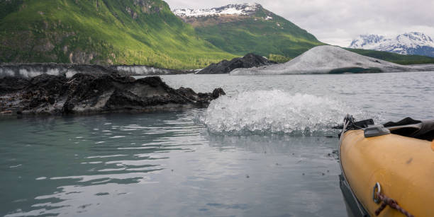 kajakfahren in alaska, gelbes kanuboot mit paddel in der nähe des eisbergs - extreme sports kayaking kayak adventure stock-fotos und bilder