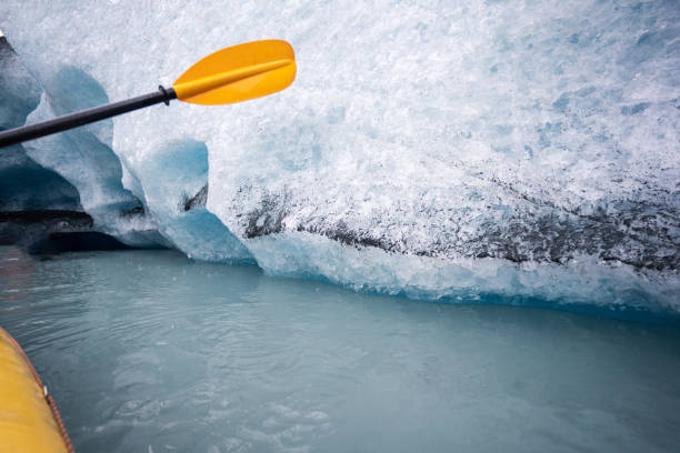 kajakfahren in alaska, gelbes kanuboot mit paddel in der nähe des eisbergs - extreme sports kayaking kayak adventure stock-fotos und bilder