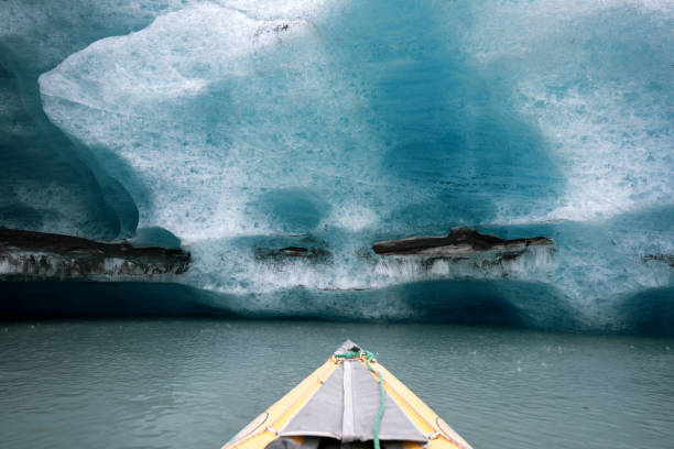 kajakfahren in alaska, gelbes kanuboot mit paddel in der nähe des eisbergs - extreme sports kayaking kayak adventure stock-fotos und bilder